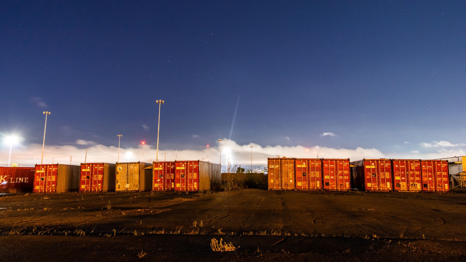 rows of used shipping containers staged in a Kansas City area container yard at dusk