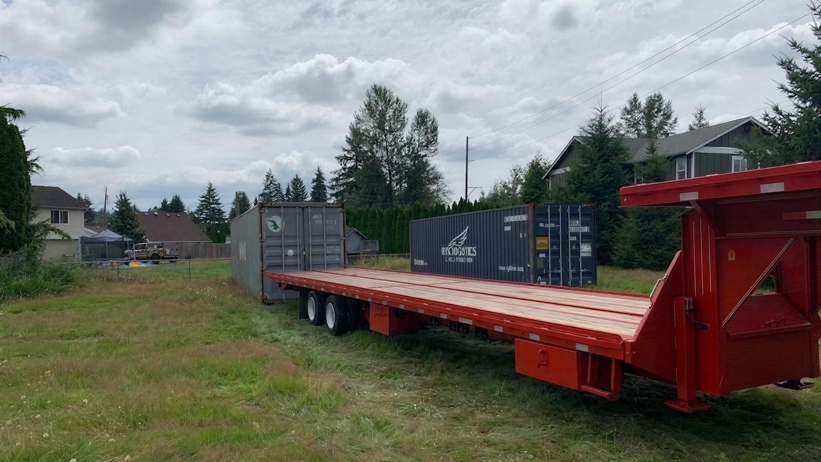 tilt-bed trailer aligned on a straight approach to place a container